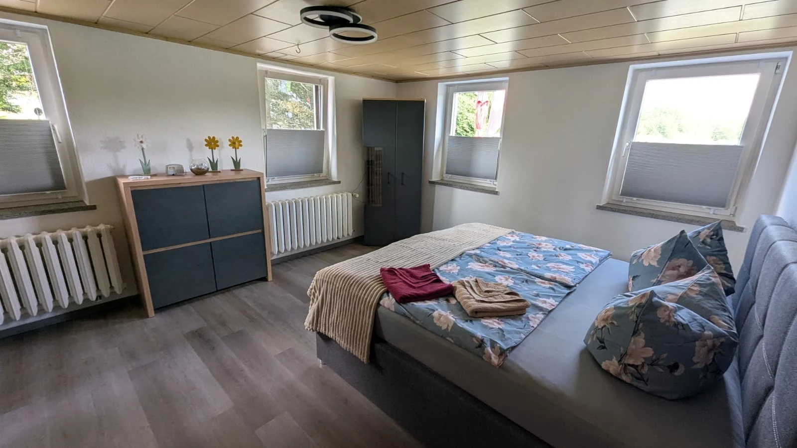 Pensionszimmer im Obergeschoss mit Doppelbett und Schrankwand